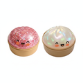 2 kawaii dumpling squishy toys in gold tin containers on white background