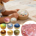 4 kawaii dumpling squishy toys in gold tin containers on white background
